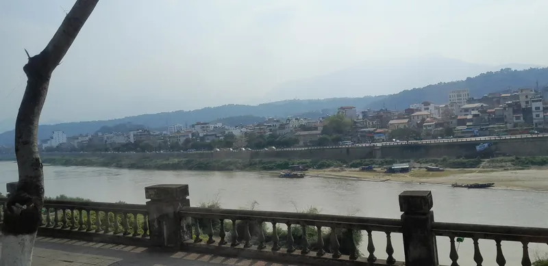 Lan can đá nhìn ra sông Hồng với thị trấn mờ sương bên kia bờ tại Lào Cai, gần biên giới Trung Quốc.