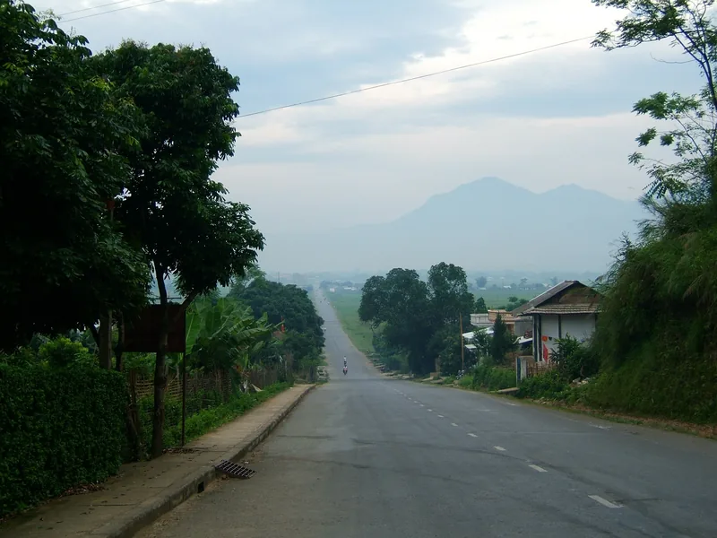 Con đường nông thôn yên tĩnh trải dài về phía núi mờ sương gần Nghĩa Lộ, Yên Bái.