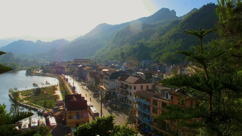 Toàn cảnh thị trấn Sapa với phố ven hồ và những dãy nhà mái đỏ nằm giữa núi mờ sương.