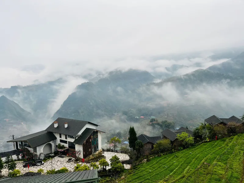 Sương mù bao phủ các thung lũng ruộng bậc thang quanh một khách sạn và bản làng trên đồi ở Sa Pa, Việt Nam.